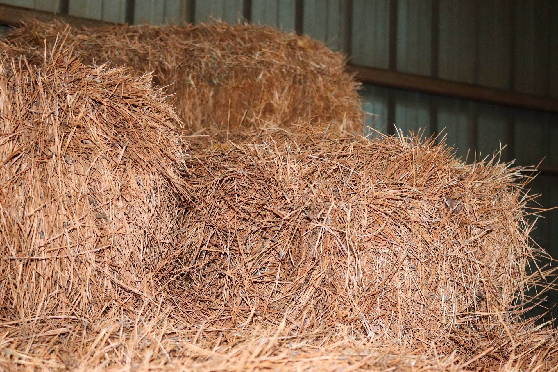 A pile of hay is stacked on top of each other in a barn.