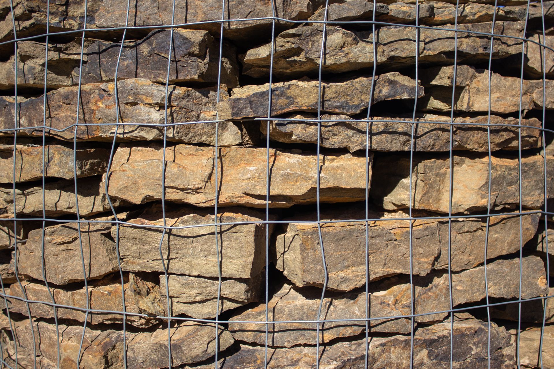 A stack of rocks behind a wire fence