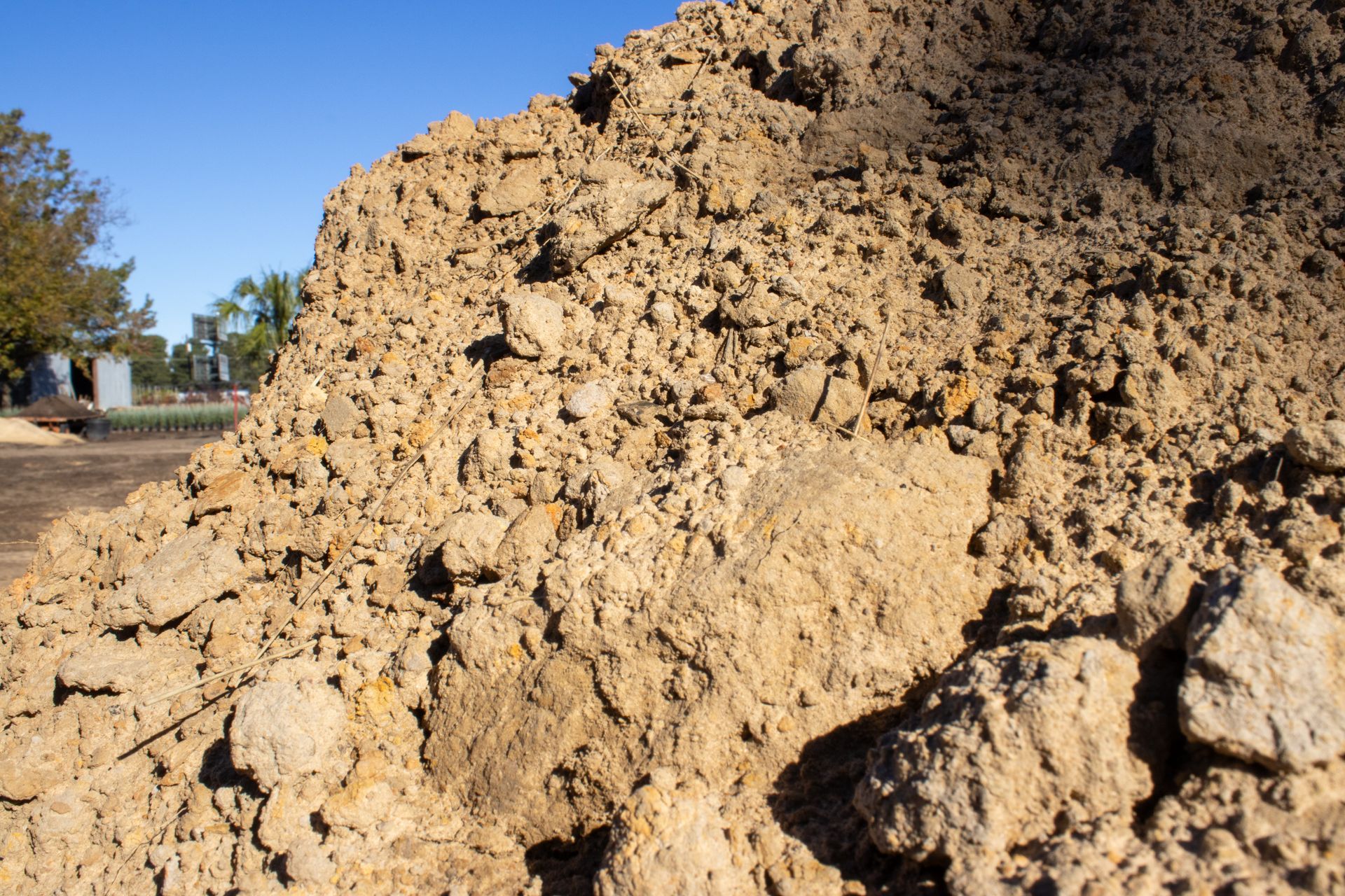A pile of dirt with trees in the background