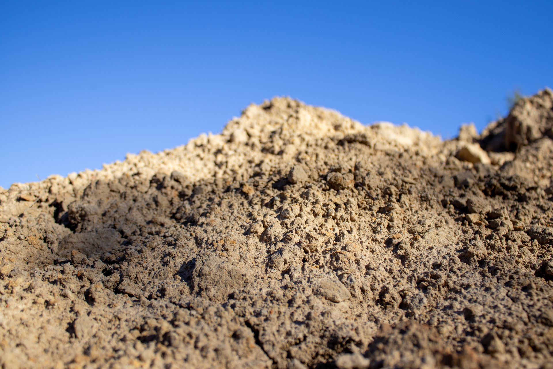 A pile of dirt with a blue sky in the background.