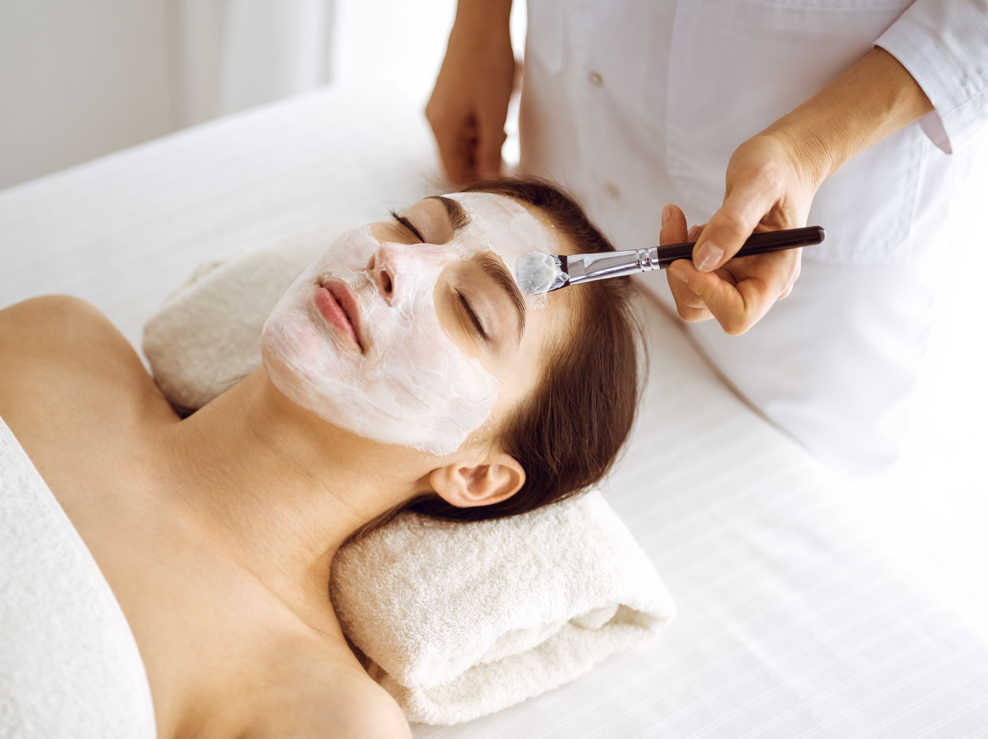 A woman is getting a facial treatment at a spa.