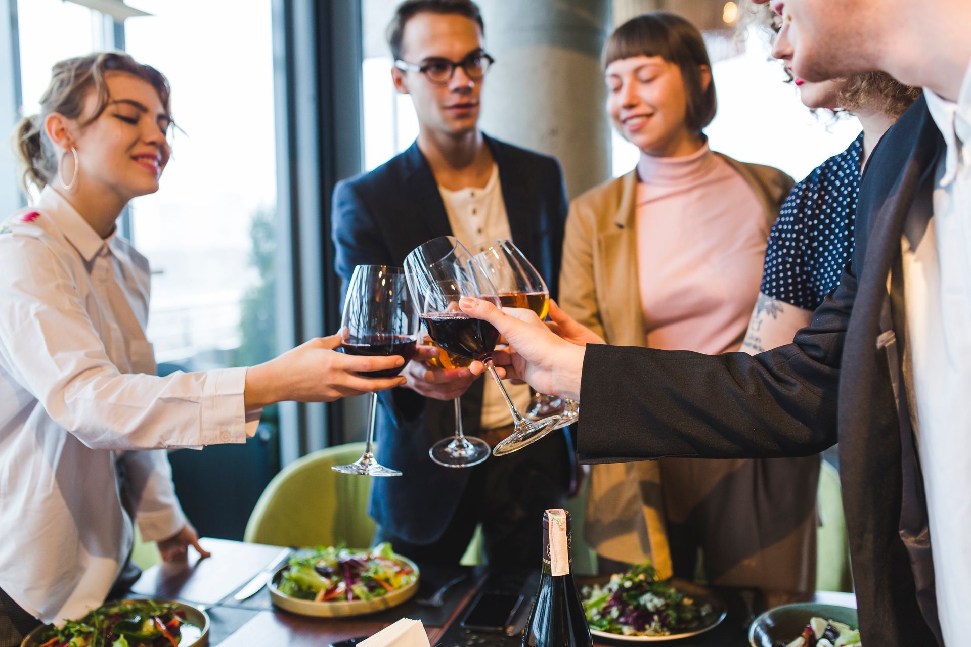 A group of people are toasting with wine glasses in a restaurant.