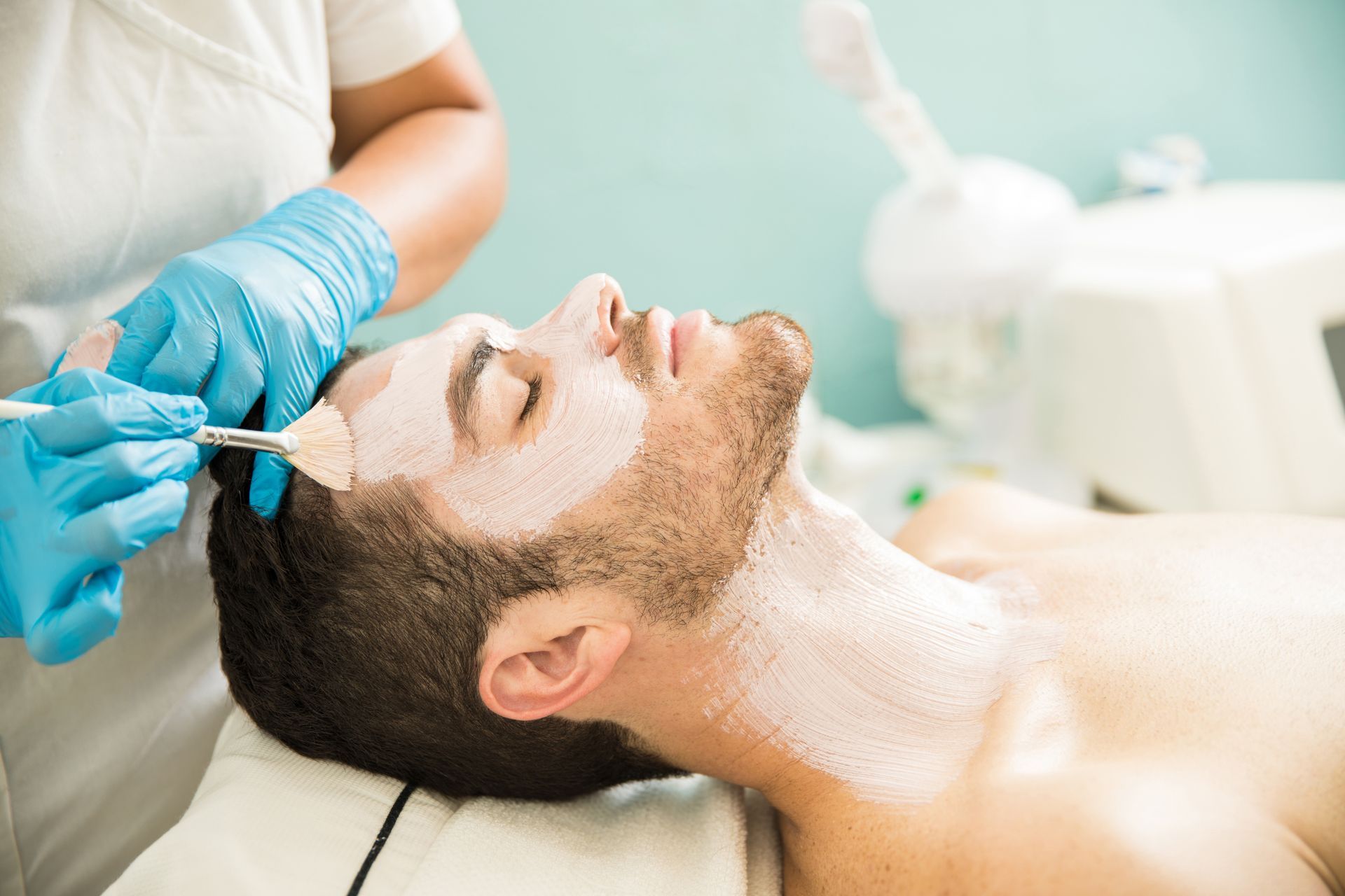 A man is getting a facial treatment at a spa.