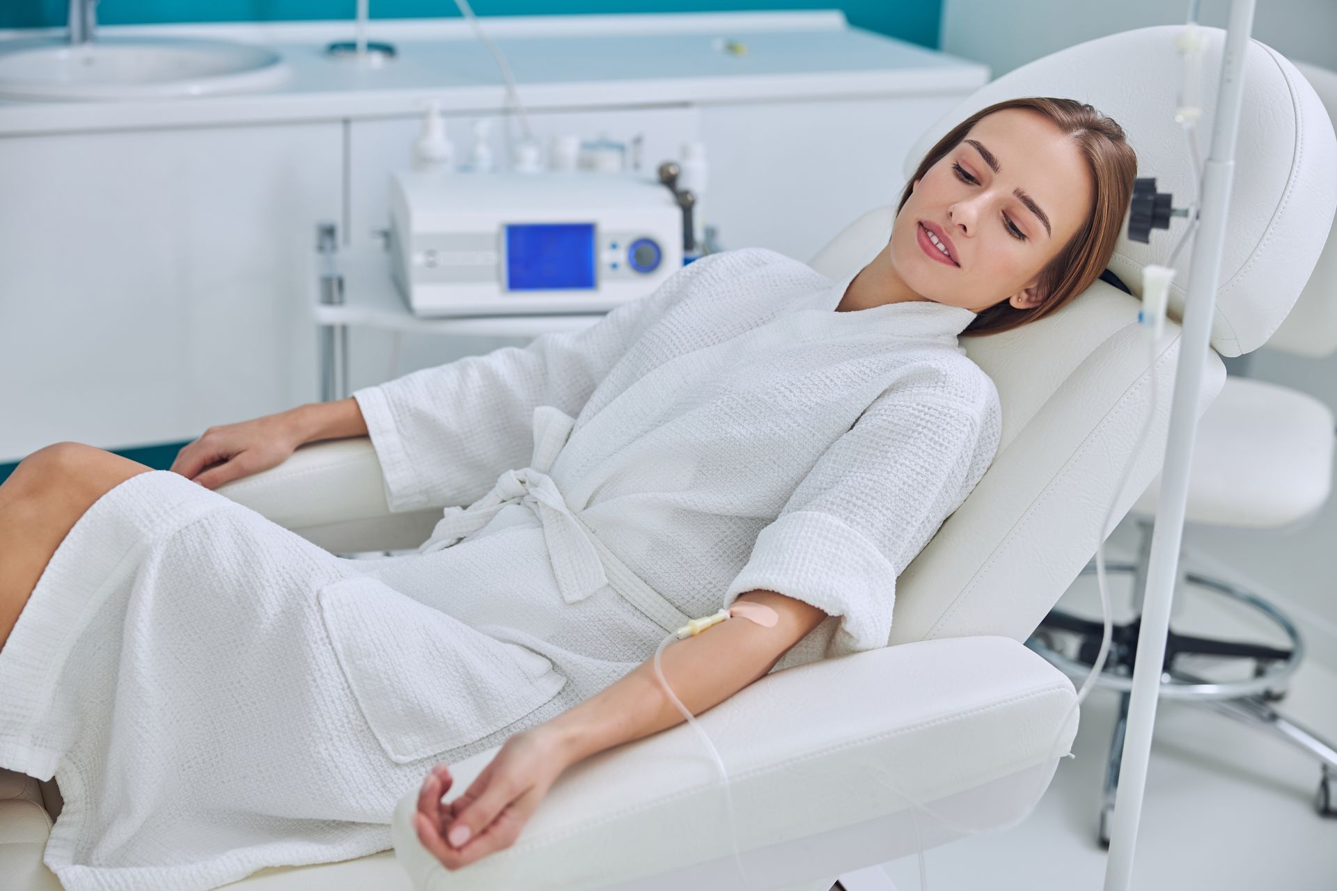 A woman is laying in a chair with an iv in her arm.