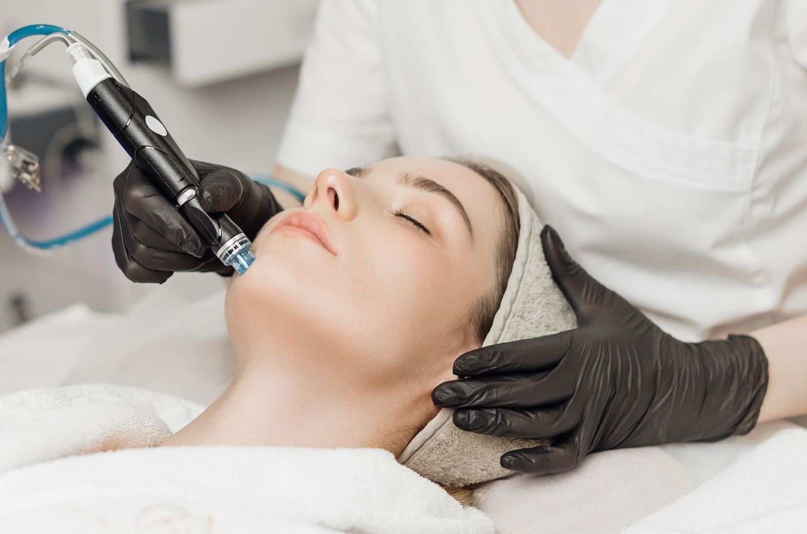 A woman is getting a facial treatment from a doctor.