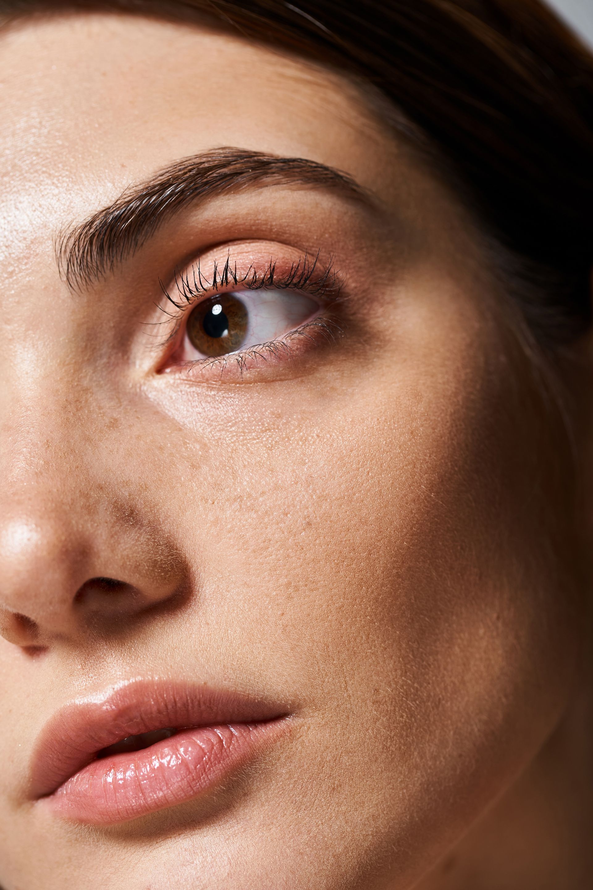 A close up of a woman 's face with a brown eye and freckles.
