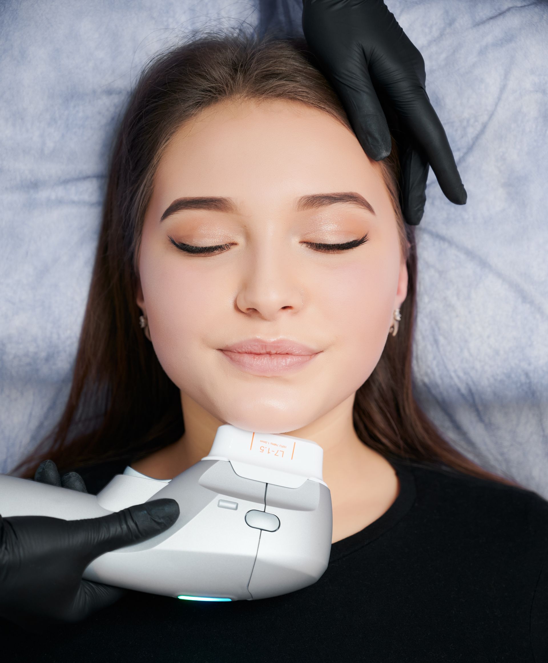 A woman is getting a facial treatment with her eyes closed