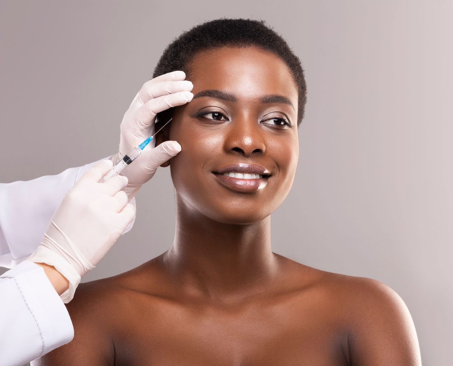 A woman is getting a botox injection in her face.