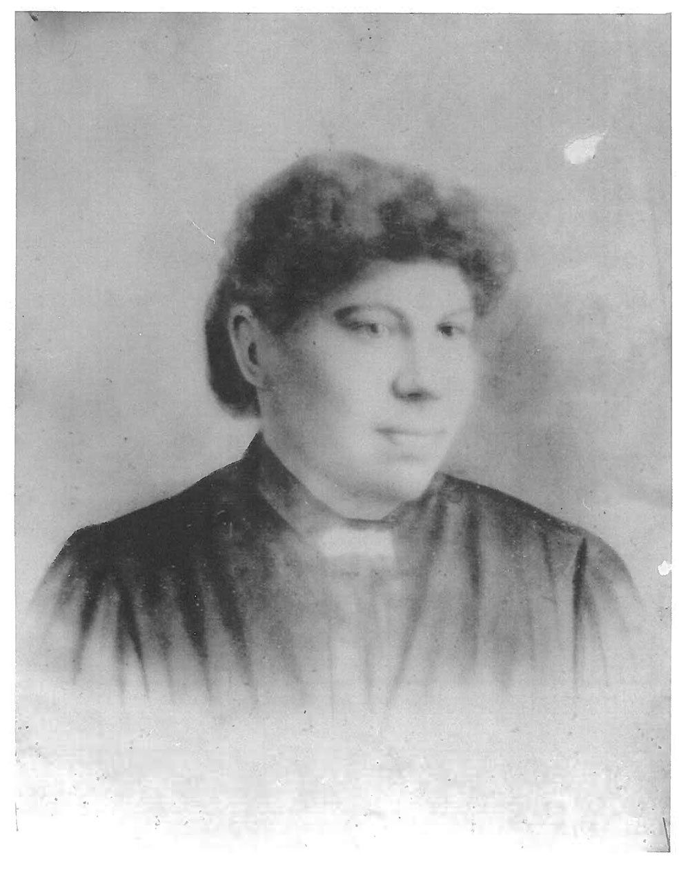 A black and white photo of a woman with curly hair.