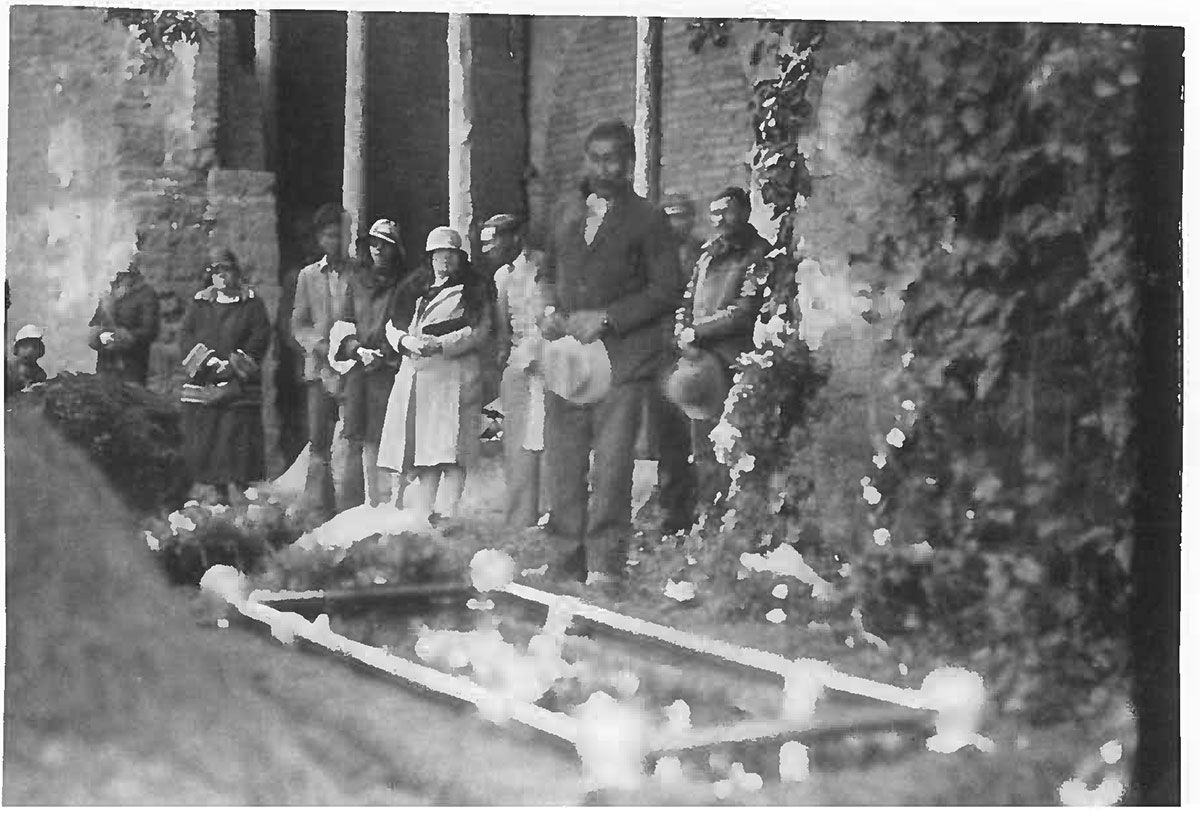 A black and white photo of a group of people standing in front of a building.