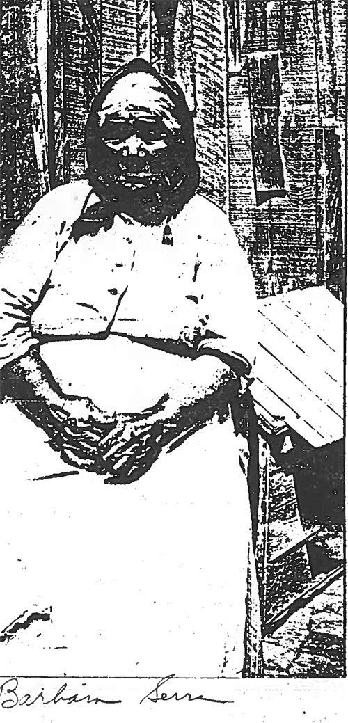 A black and white photo of a woman sitting on a bench.