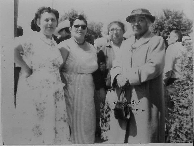 A group of people standing next to each other in a black and white photo.