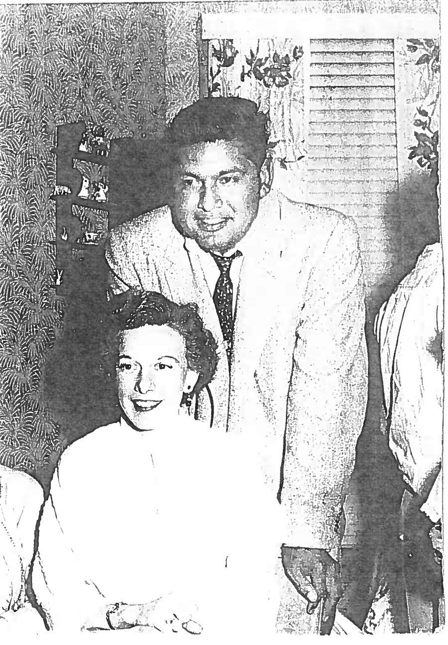 A black and white photo of a man and woman posing for a picture.
