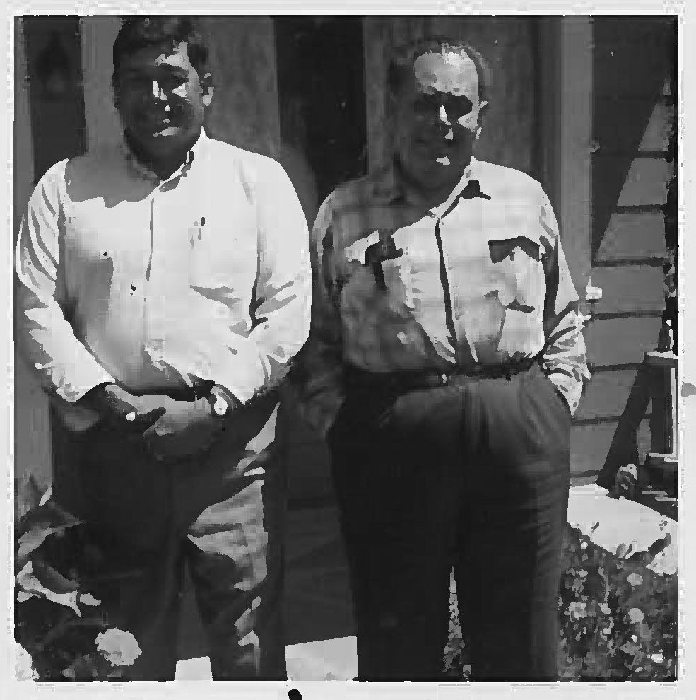 Two men standing next to each other with their hands in their pockets