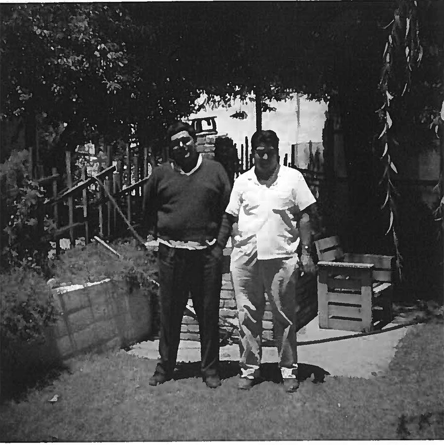 A black and white photo of two men standing next to each other
