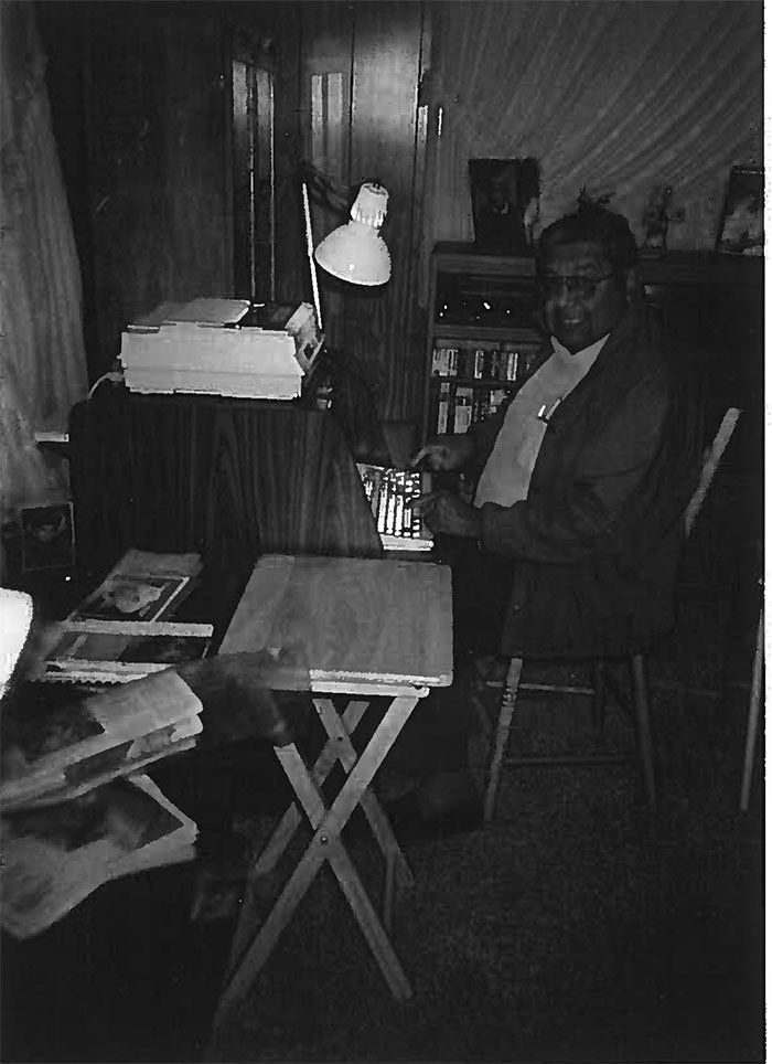 A black and white photo of a man sitting at a desk