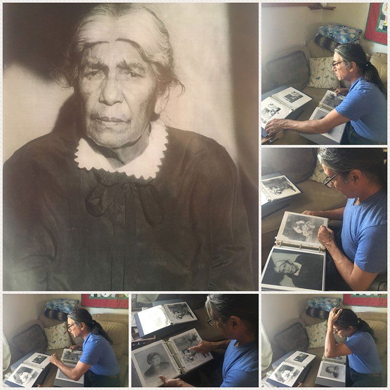 A woman in a blue shirt is looking at old photographs