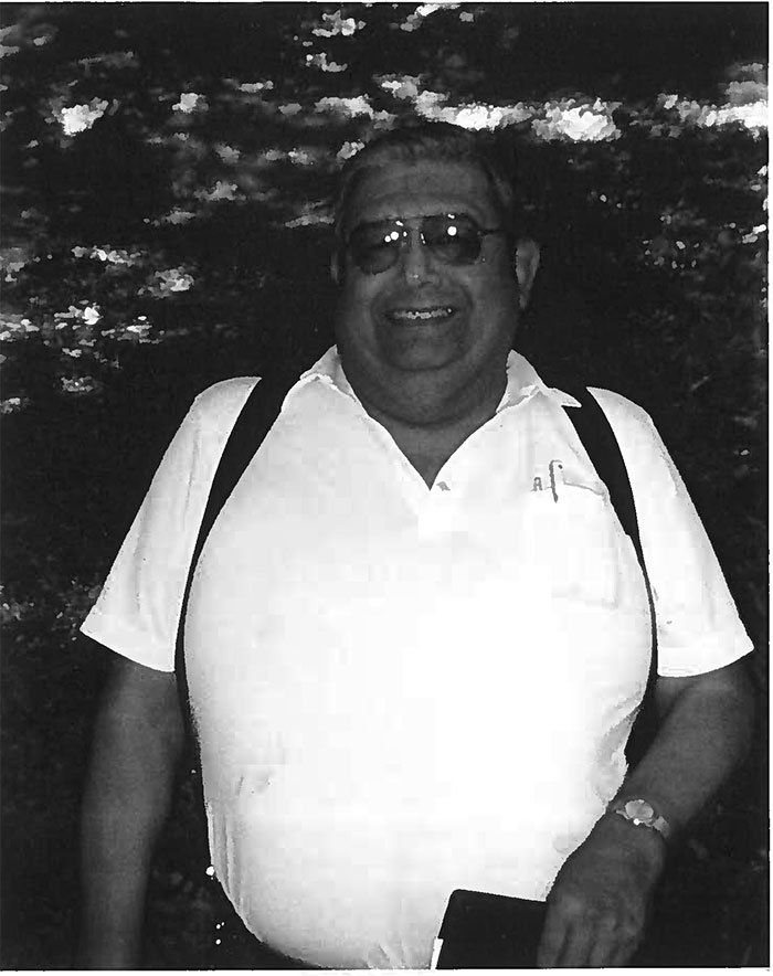A black and white photo of a man wearing sunglasses and a white shirt