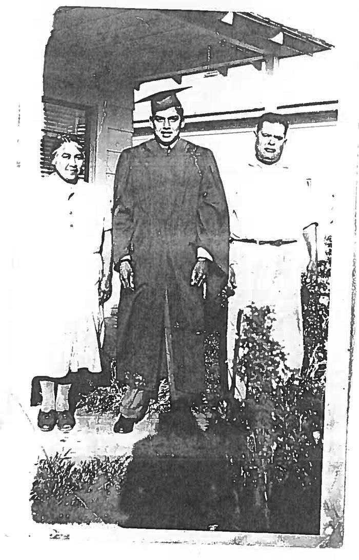 A black and white photo of three people standing in front of a building