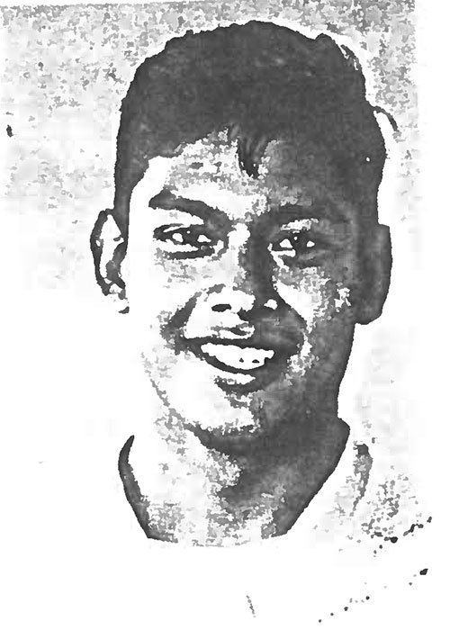 A black and white photo of a young man smiling