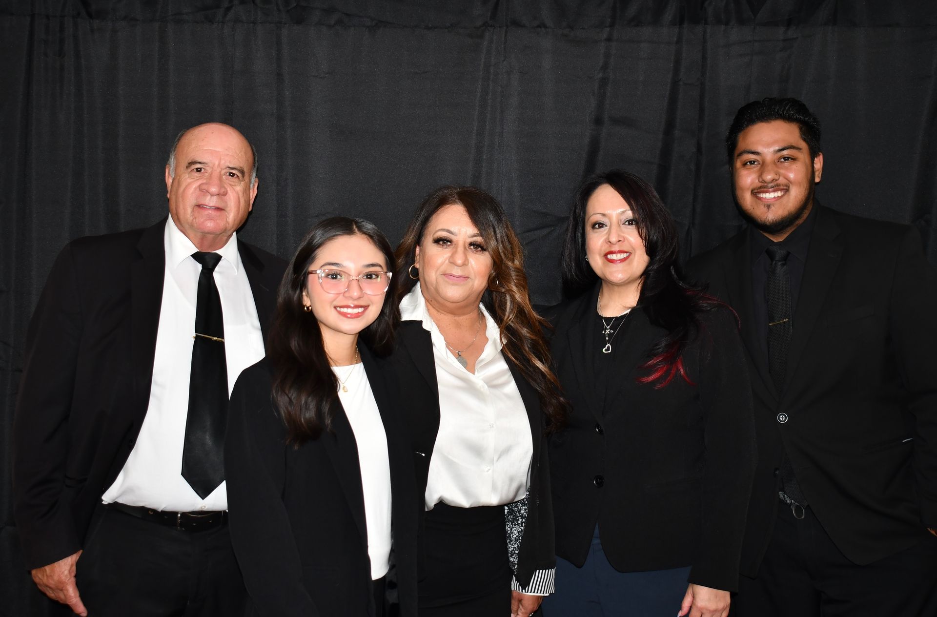 A group of people in suits and ties are posing for a picture.