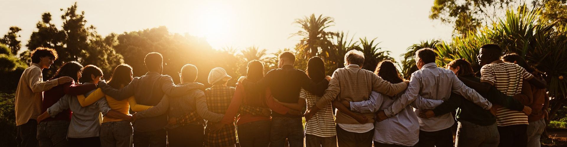 a large group of people are standing in a circle with their arms around each other .