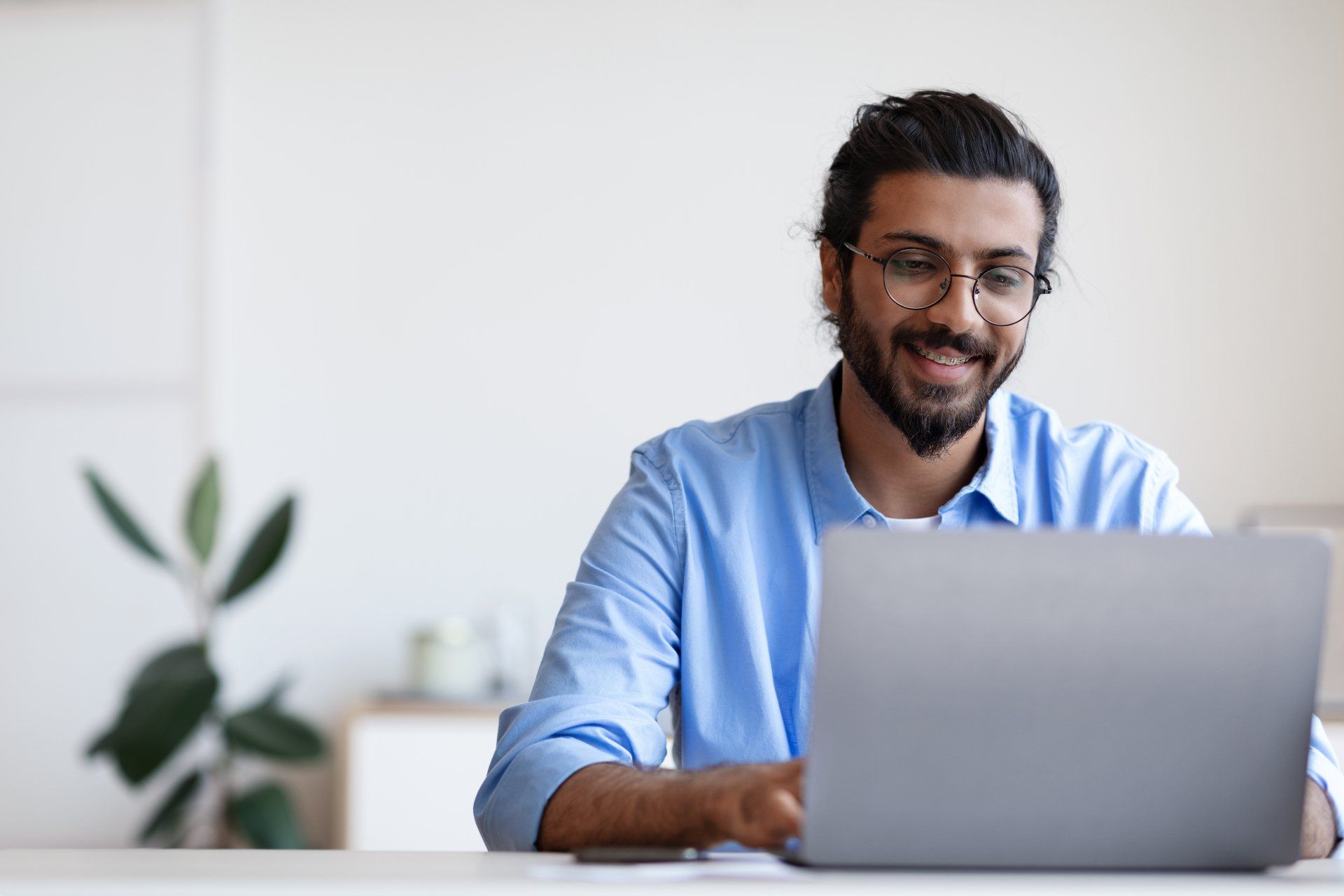 man-with-glasses-using-laptop-to-research-database