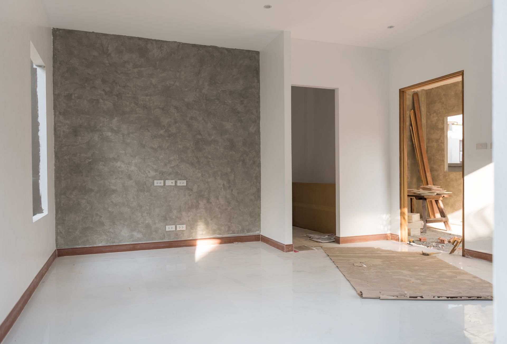An empty room with a concrete wall and a door.