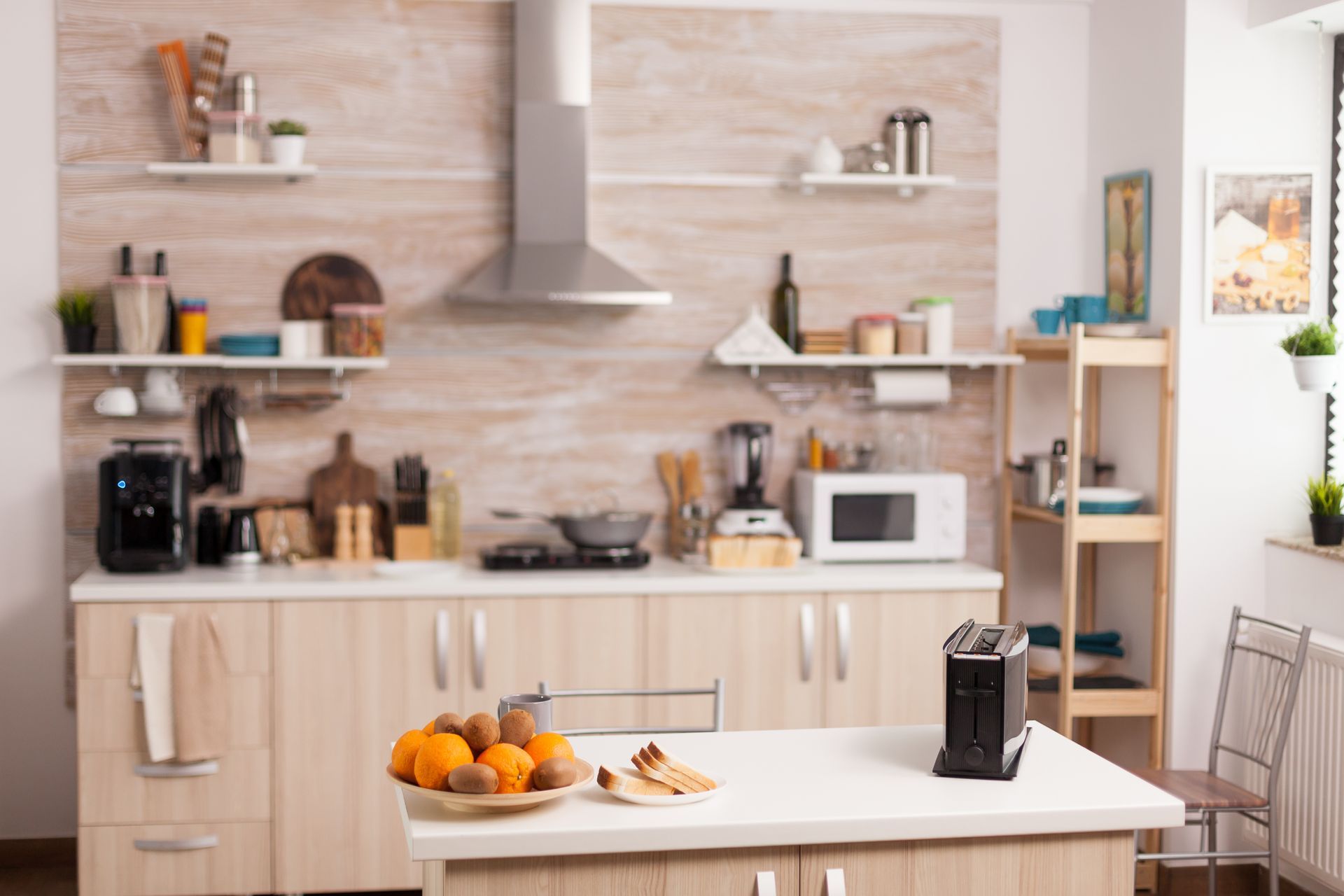 Modern kitchen with white cabinets, wood accents, open shelves, and a fruit bowl on the island.