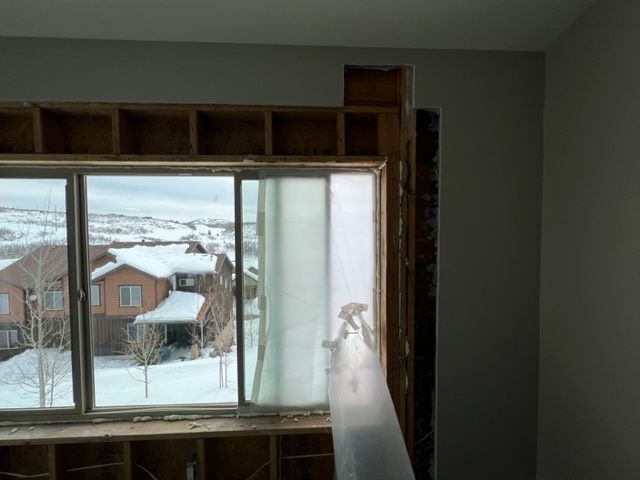 A window in a room with a view of snow covered houses.