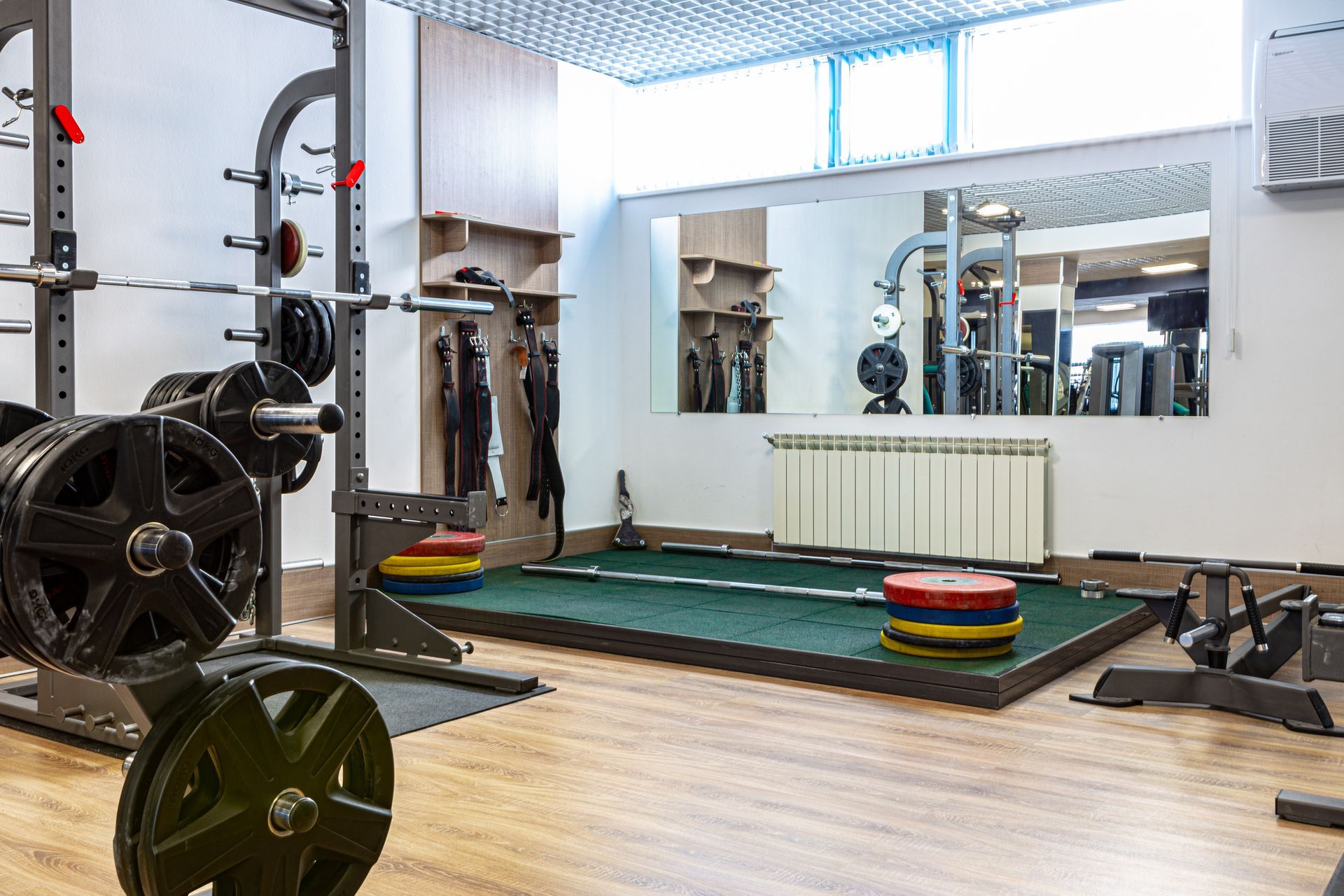 A gym with a lot of exercise equipment and a large mirror.