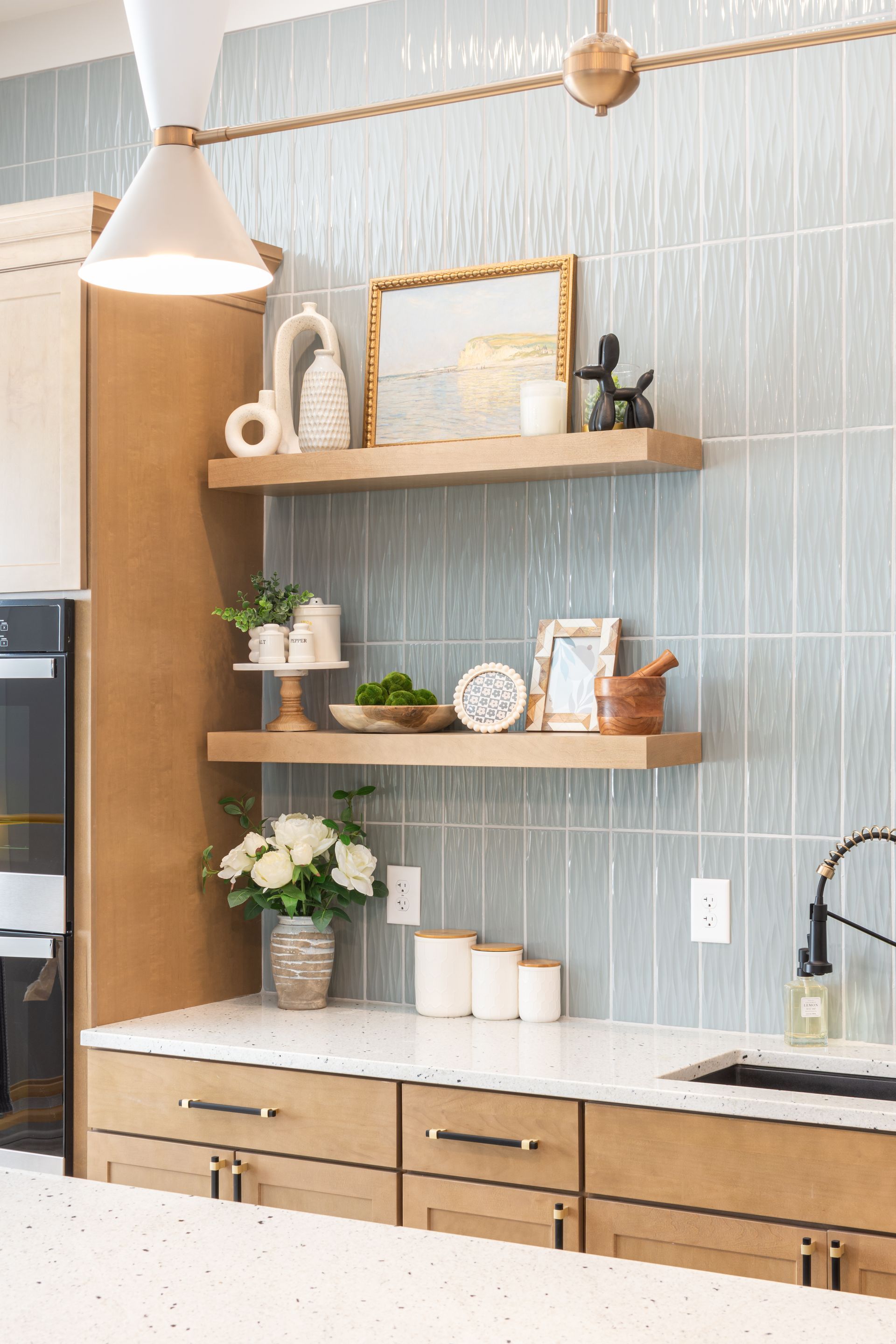 A kitchen with a sink , cabinets , shelves , and a mirror at Riverstone.