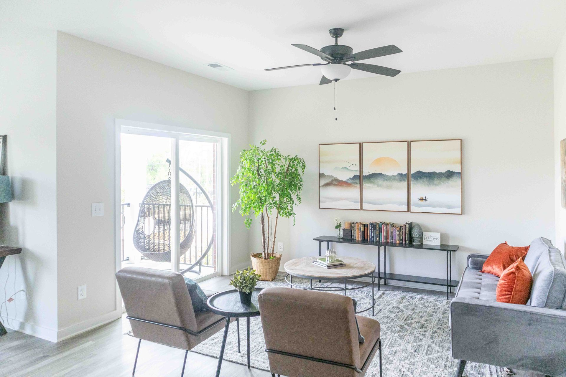 A living room with a couch , chairs , a table and a ceiling fan at Riverstone.