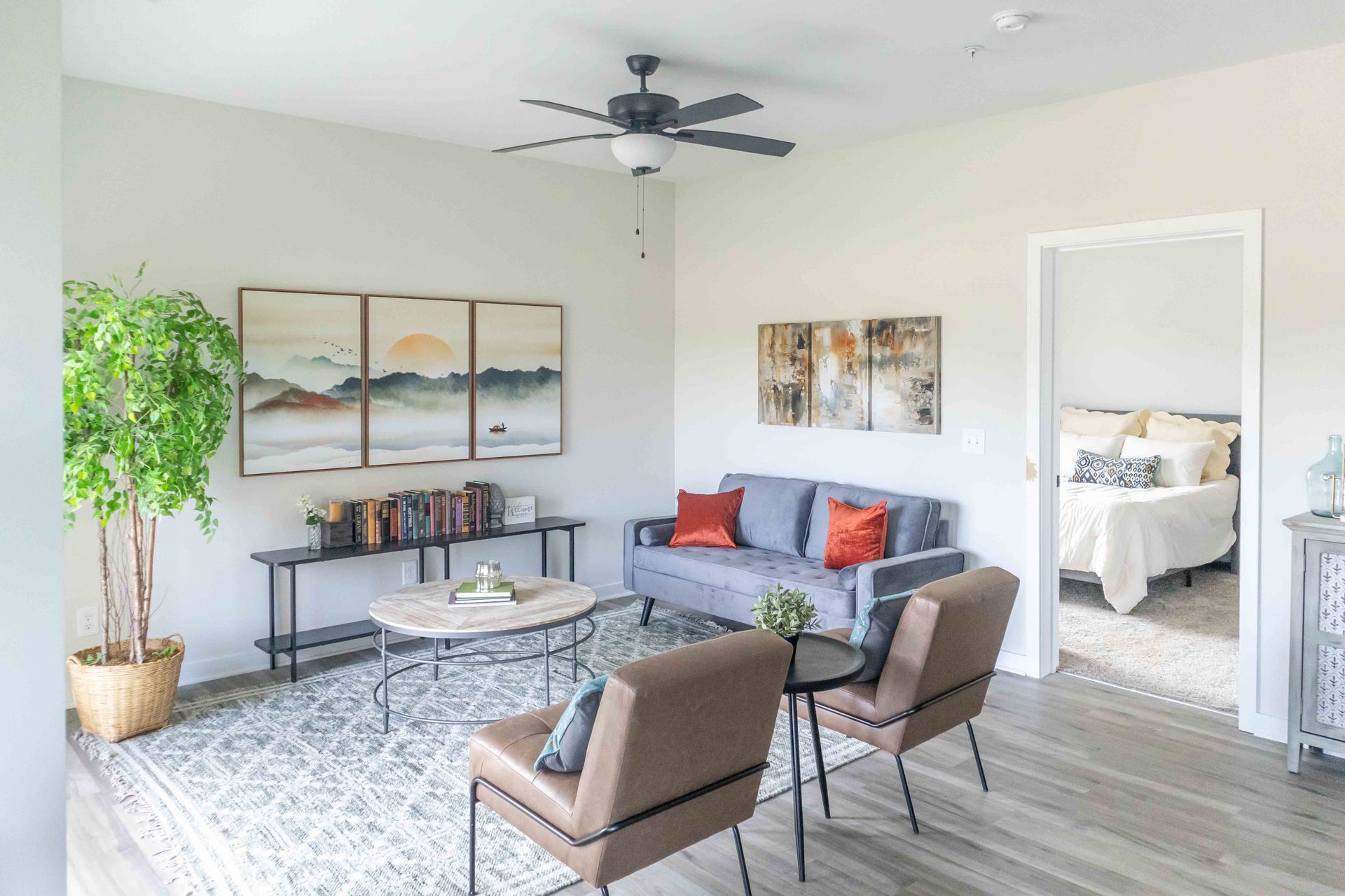 A living room with a couch , chairs , a coffee table and a ceiling fan at Riverstone.