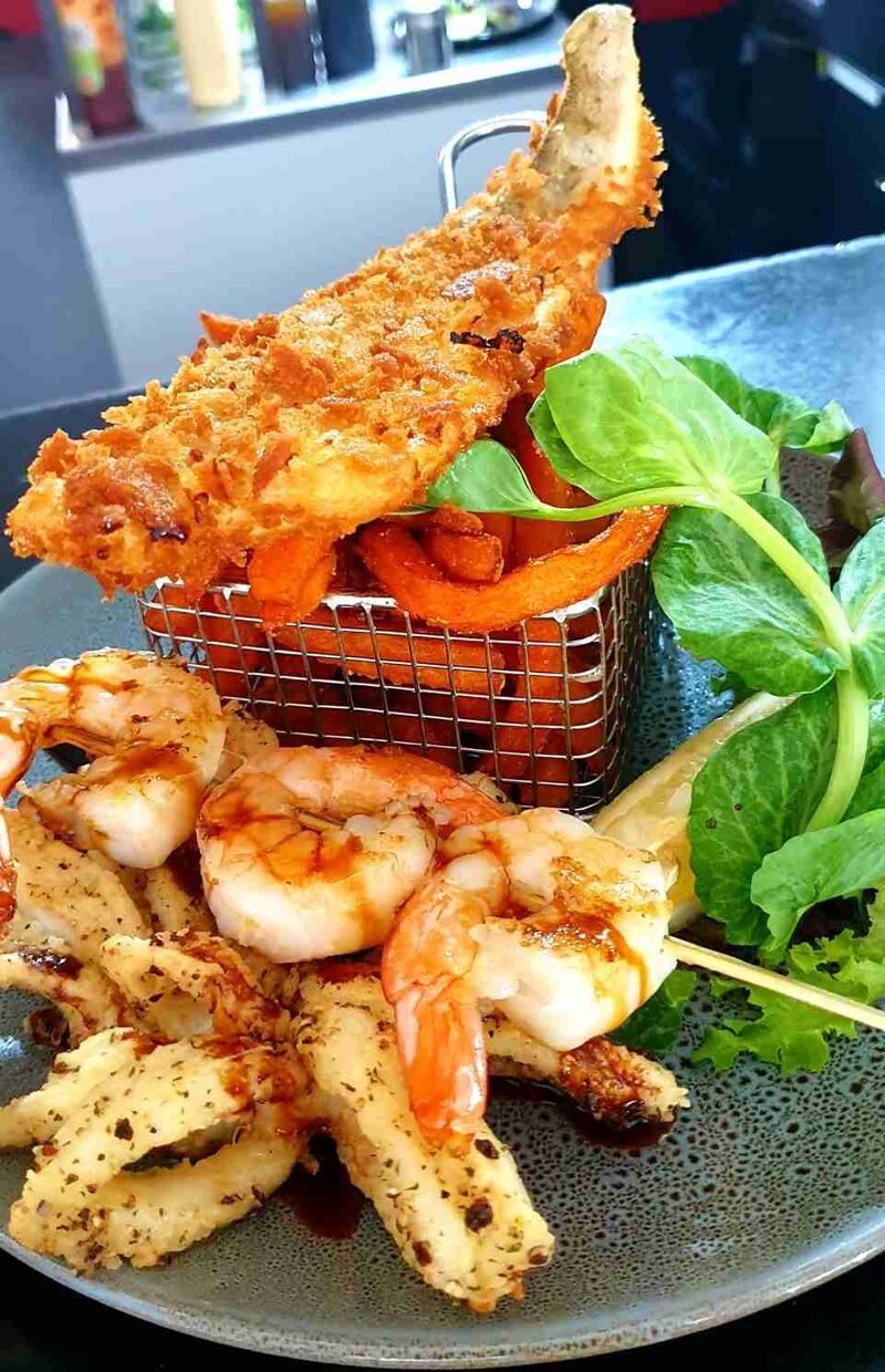 A plate of food with shrimp and squid on a table.