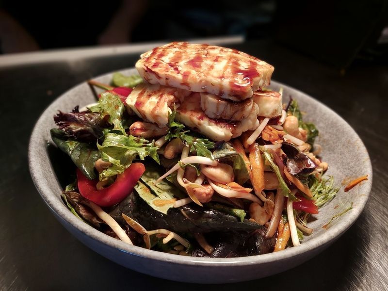 A salad with meat and vegetables in a bowl on a table.