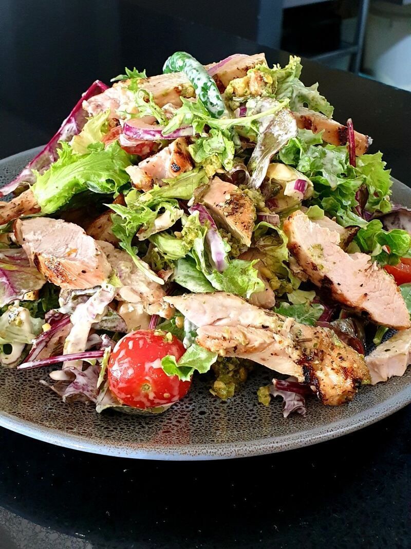 A close up of a salad on a plate on a table.