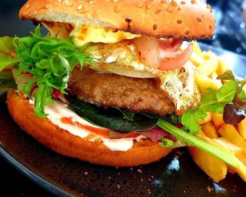 A close up of a hamburger and french fries on a plate