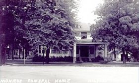 A black and white photo of a house with trees in front of it.