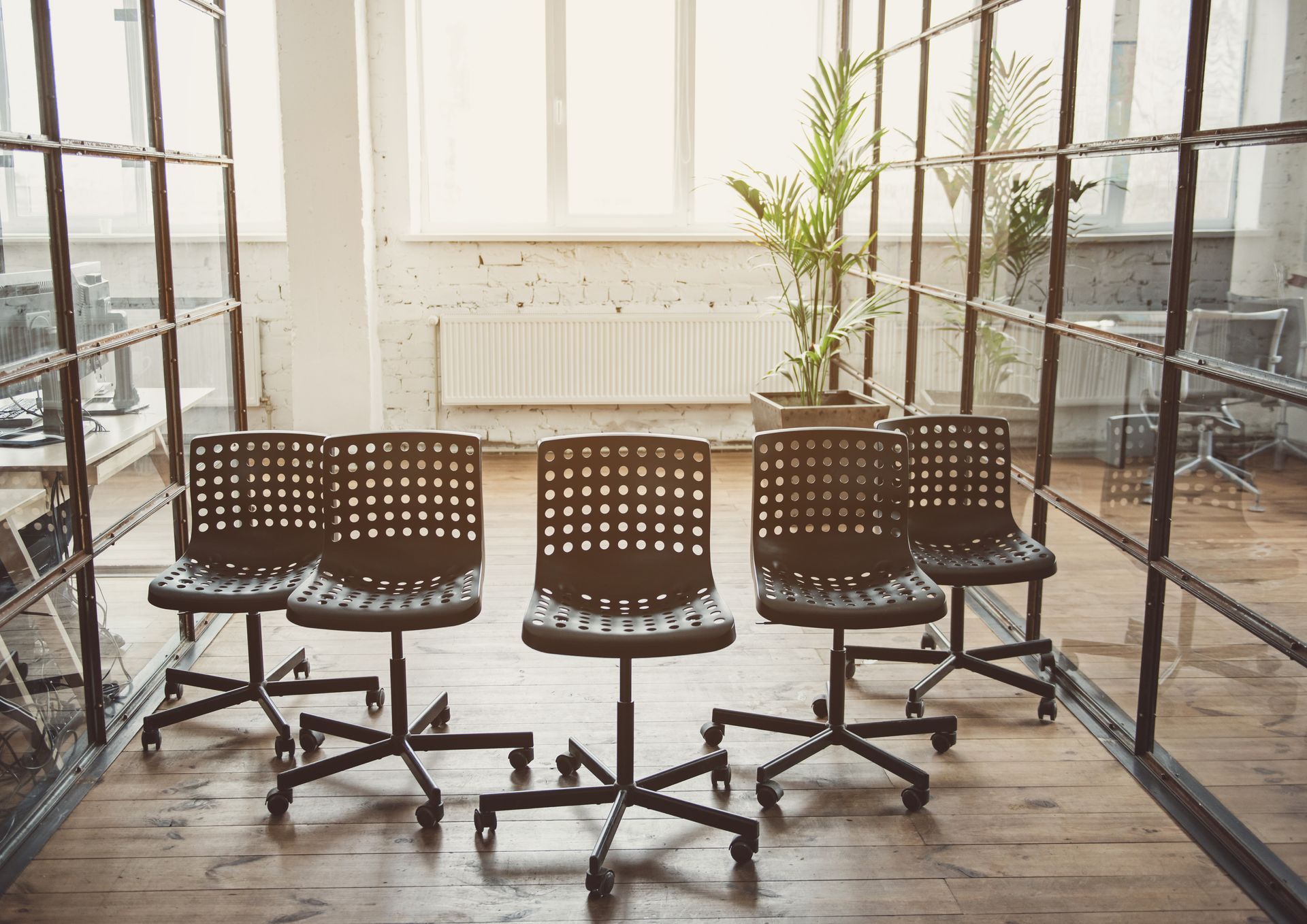 Modern black seats located in the bright contemporary hall of an office.
