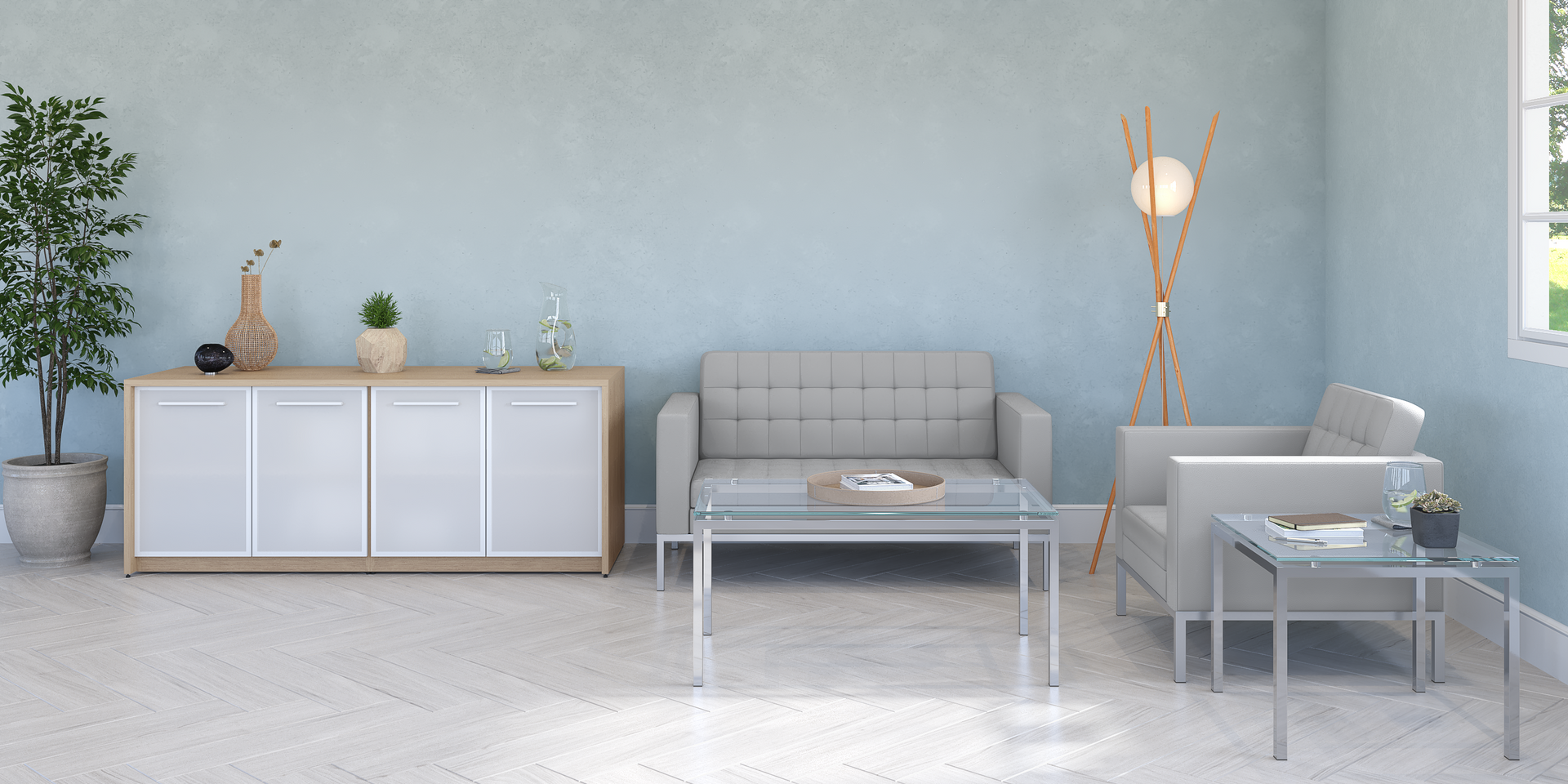 A light blue room with a light gray sofa, cabinet and tables. There is also a decorative lamp and tree.