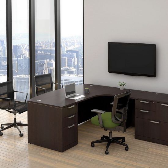 An office with a brown desk, chairs, laptop, a TV, and a city view through large windows.