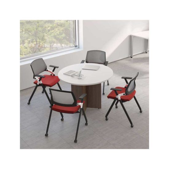 Four office chairs with red seats and a round table in a bright room.