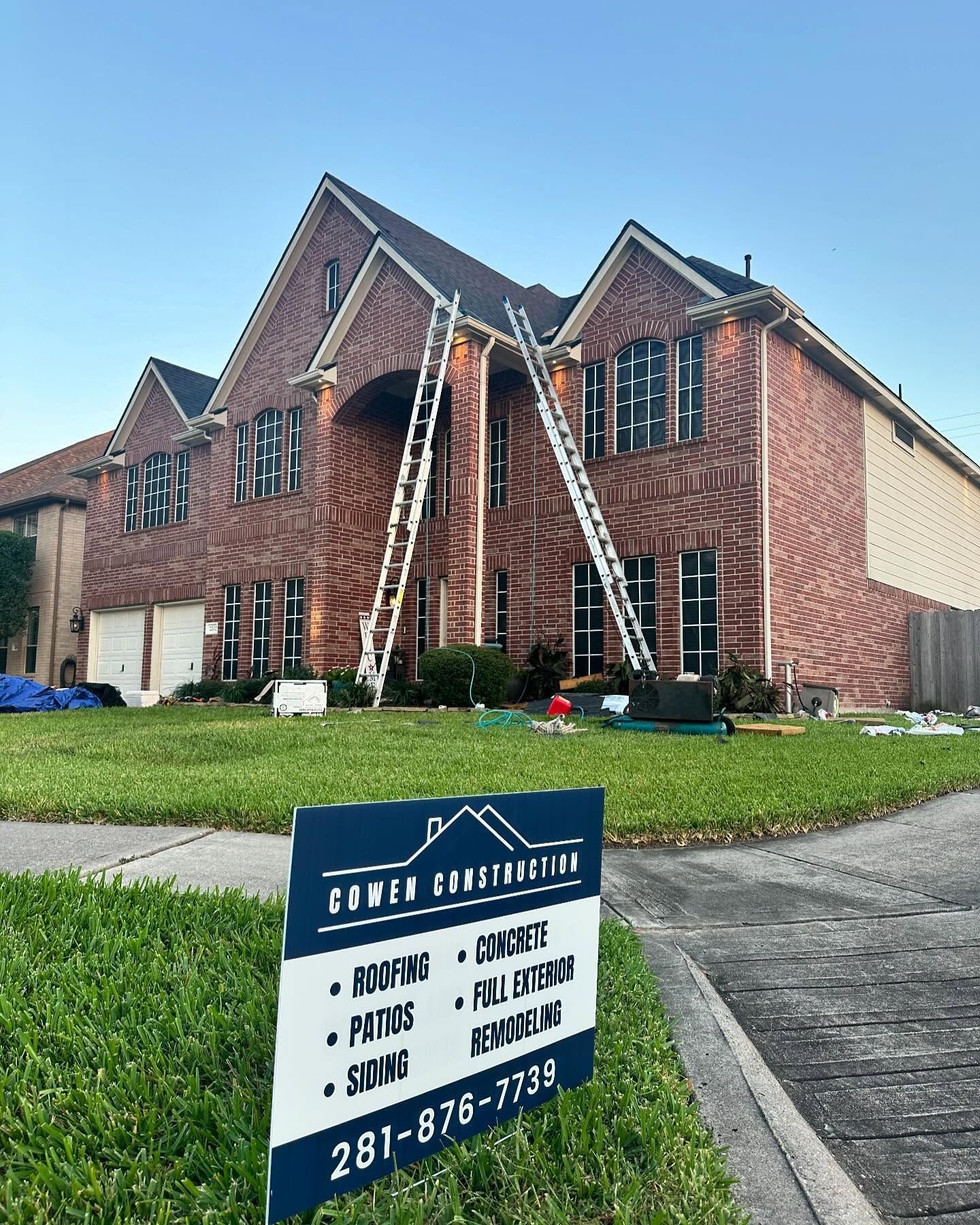 A large brick house with a sign in front of it.