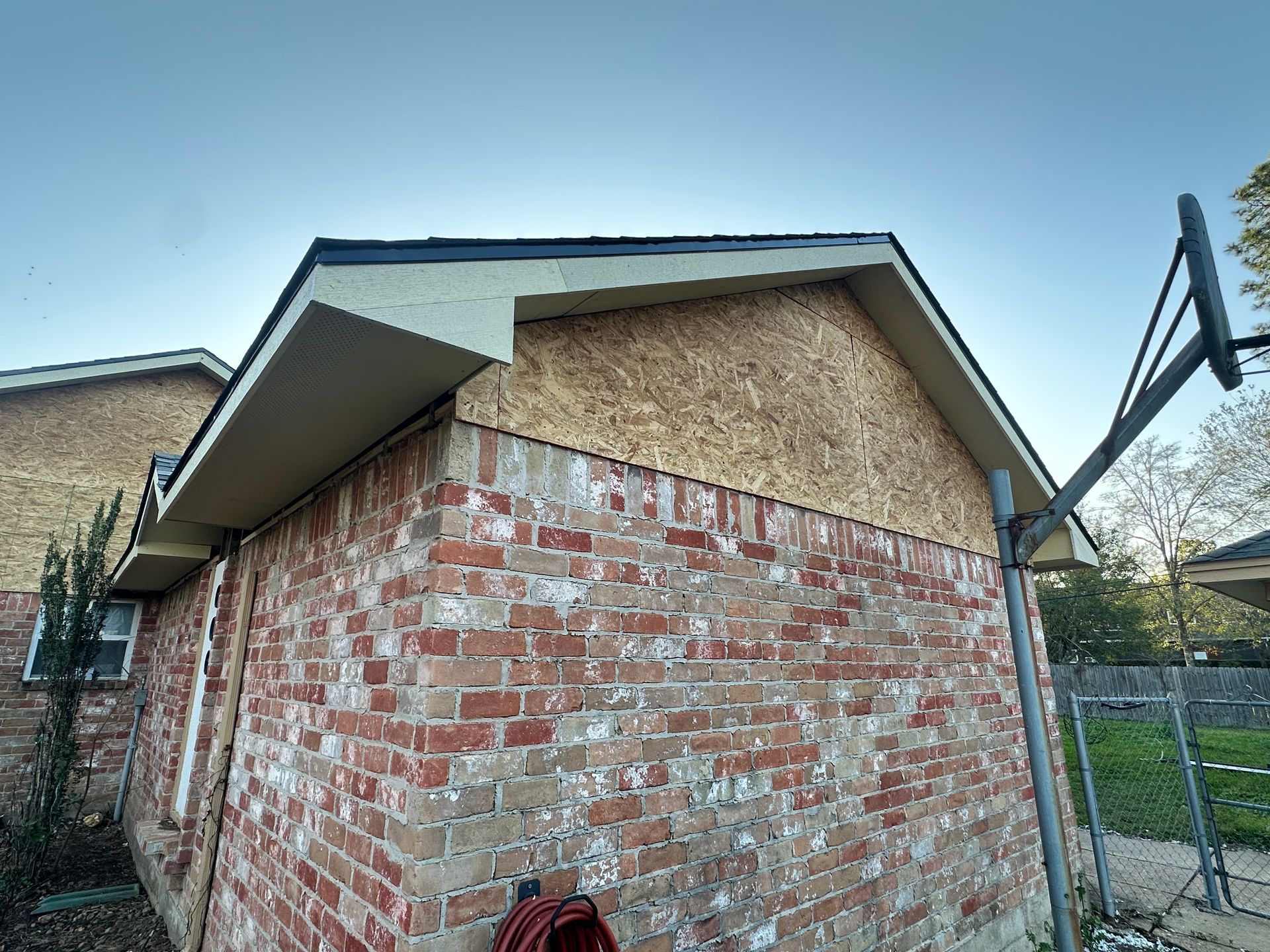Brick building with exposed wood sheathing under the roofline.