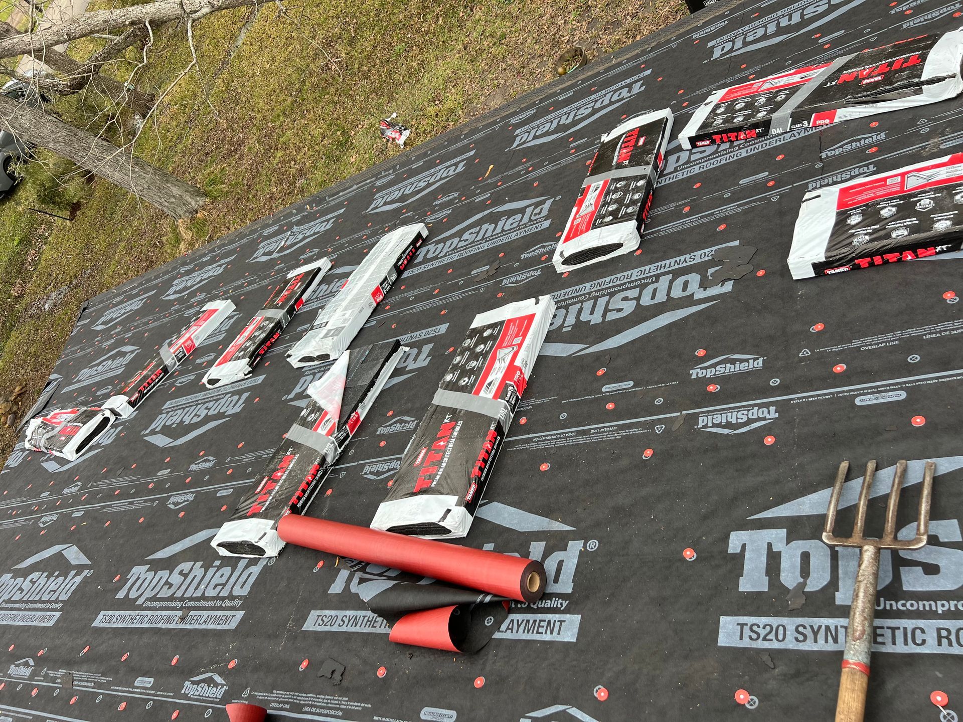 Roof underlayment with several roofing fasteners laid out, tool.