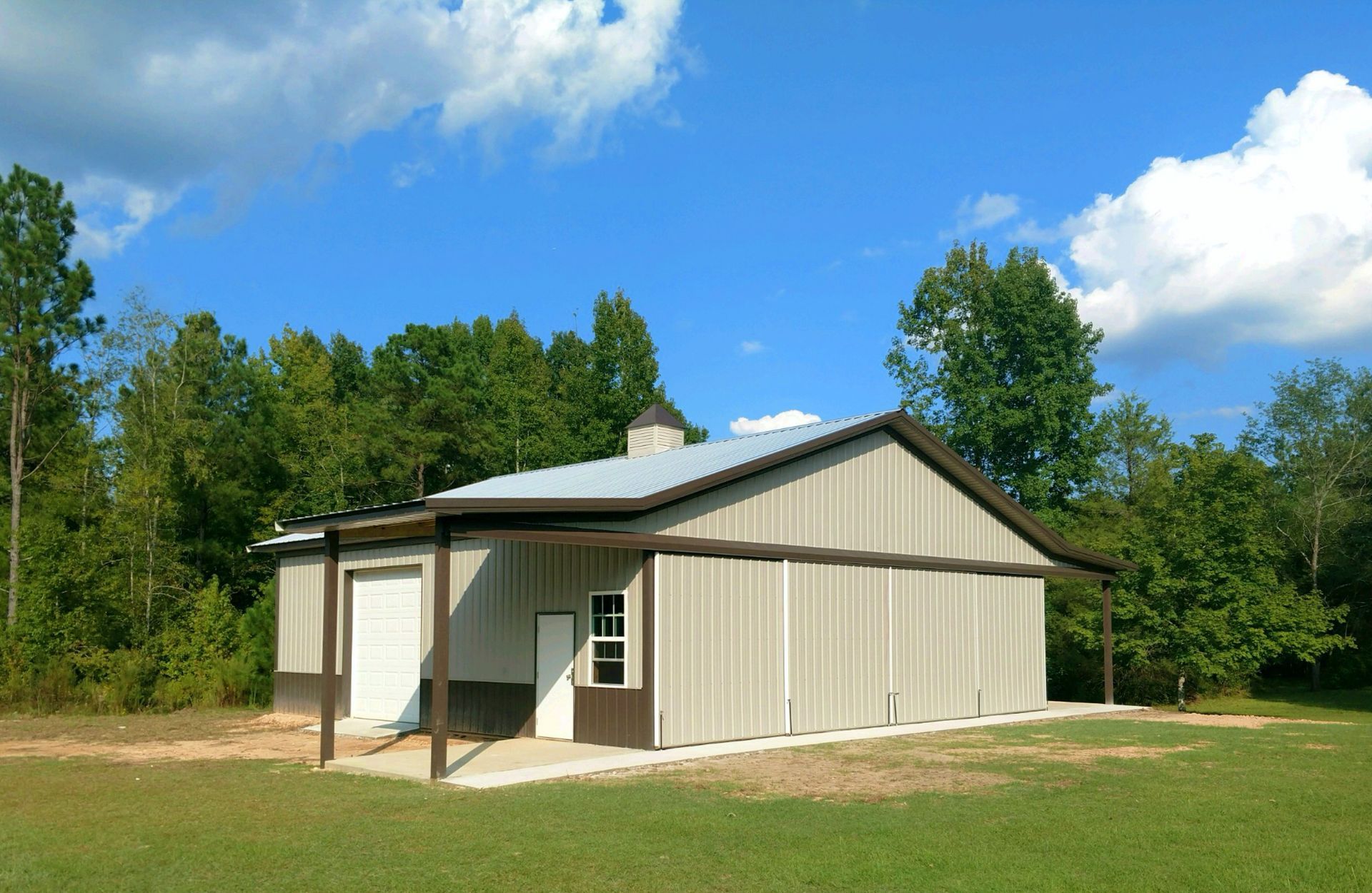 A large building in the middle of a field with trees in the background