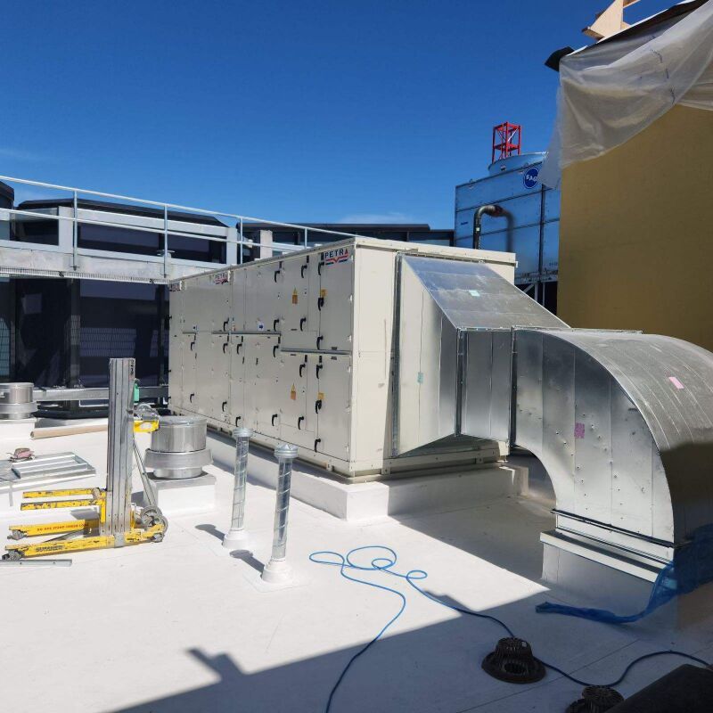 A rooftop with a lot of pipes and boxes on it