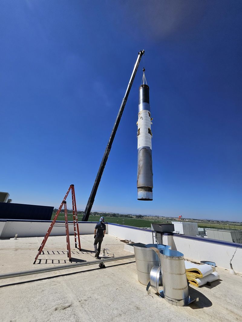 A large object is being lifted by a crane on top of a building.