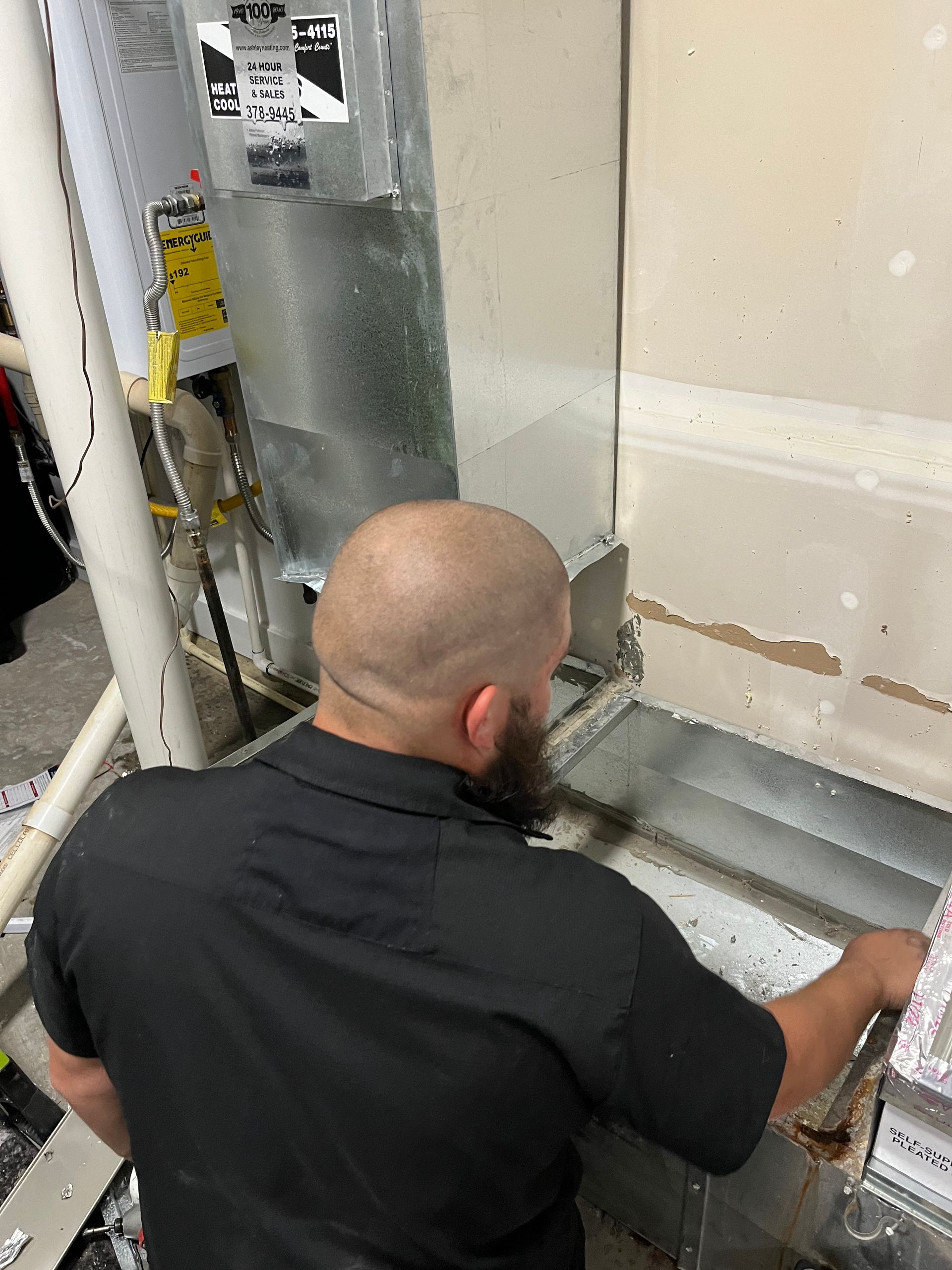 A man is working on an air conditioner in a room.